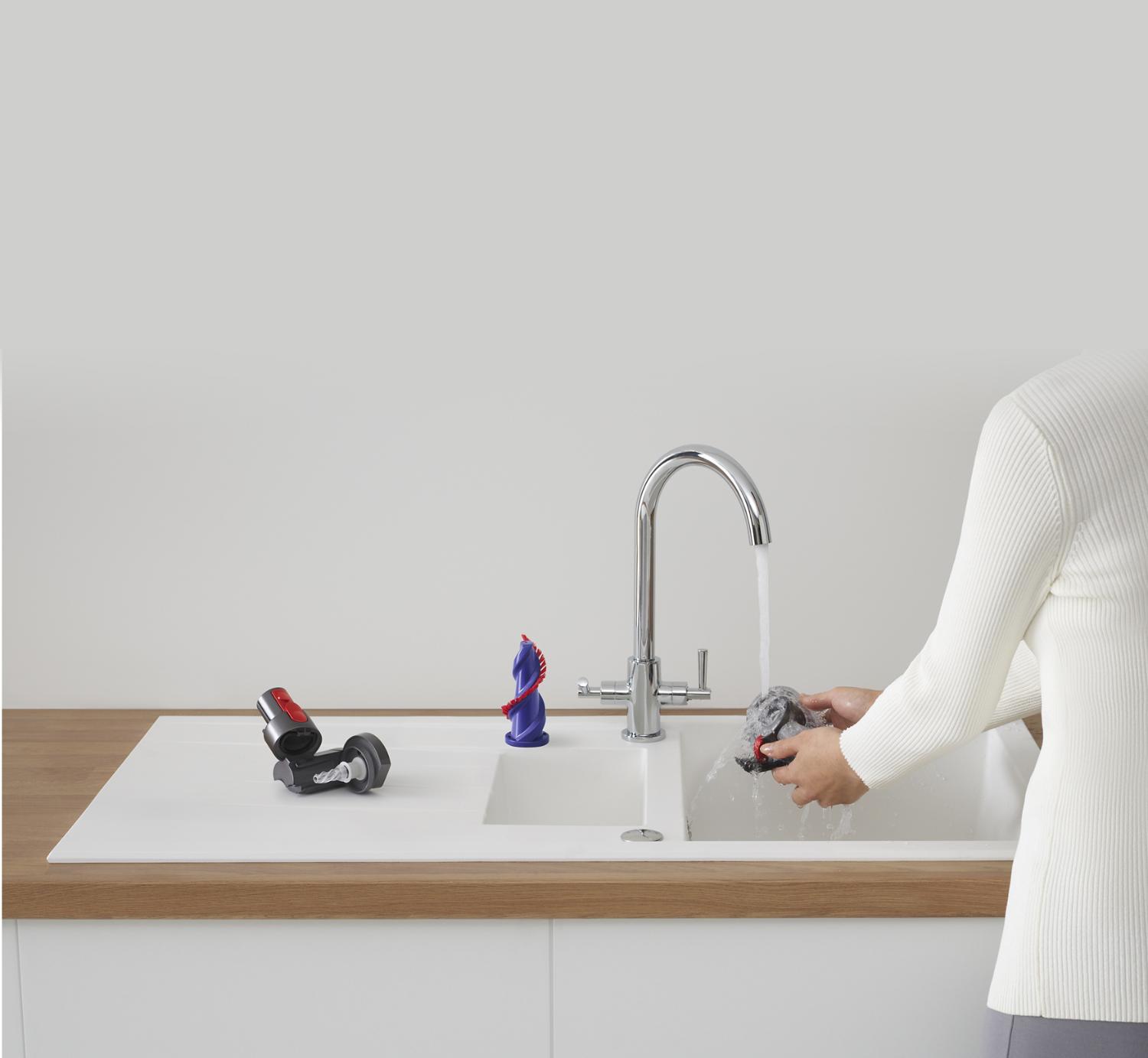 Dyson tools being cleaned at a sink